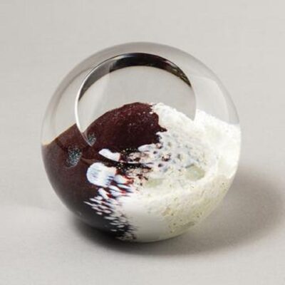 A glass ball with white and brown paint on it.