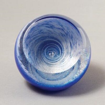 A blue glass bowl with swirling design on it.