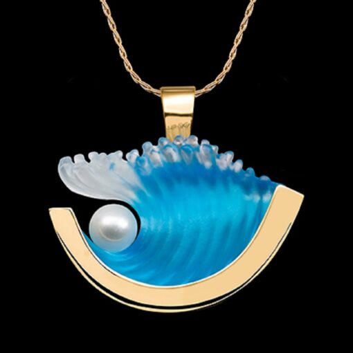 A necklace with a wave and pearl on it