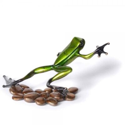A green frog is on top of some coffee beans.