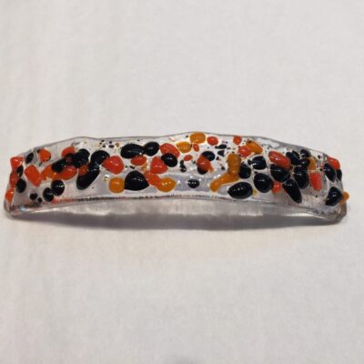 A white headband with black and orange dots on it.