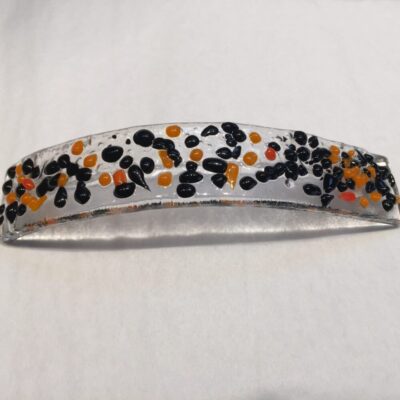 A white headband with black and orange dots.