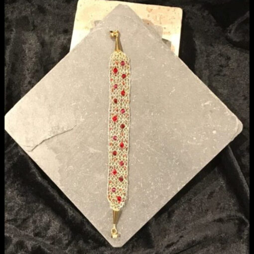 A bracelet with red stars on it is sitting on top of a box.