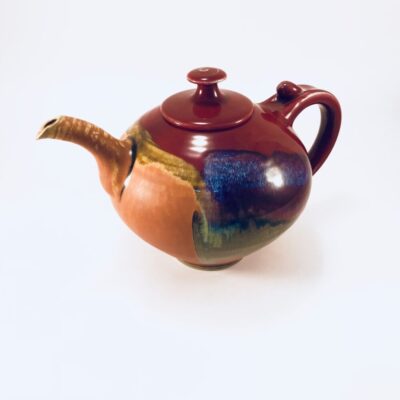A teapot with a brown and blue design on it.