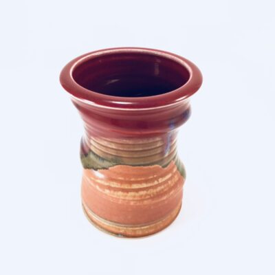A red and brown vase with a green bottom.