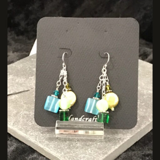 A pair of earrings hanging on a display stand.