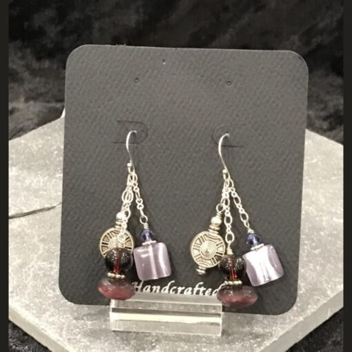 A pair of earrings hanging on a display stand.