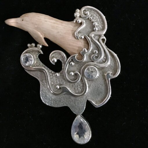 A dolphin is shown with a large stone and a crystal drop.