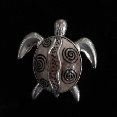 A turtle with black and white designs on it's shell.