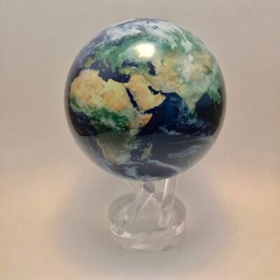 A small globe on a stand with the earth in front of it.