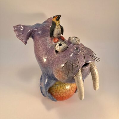 A ceramic elephant with two birds on it.