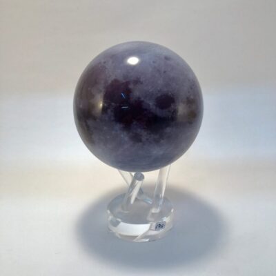 A purple sphere sitting on top of a clear stand.