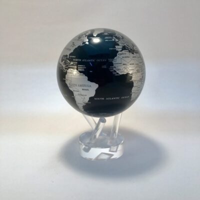 A glass globe with black and white continents on top of it.