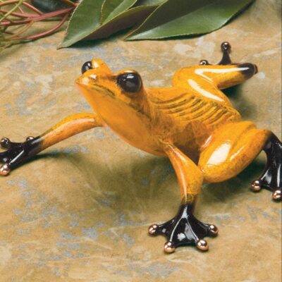 A yellow frog sitting on top of a table.