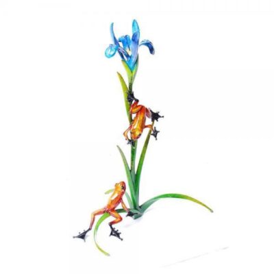 A glass sculpture of three frogs on a plant.