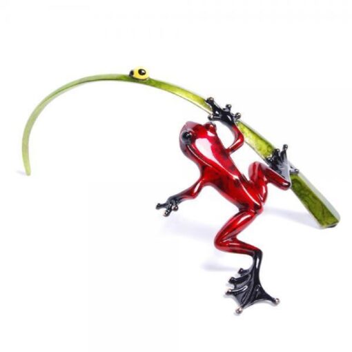 A red frog holding onto a green stick