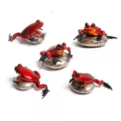 A group of five red frogs on top of metal discs.
