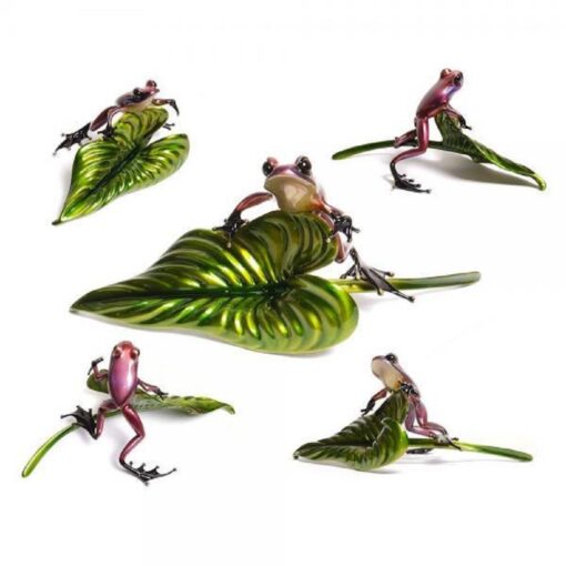 A group of frogs sitting on top of a leaf.