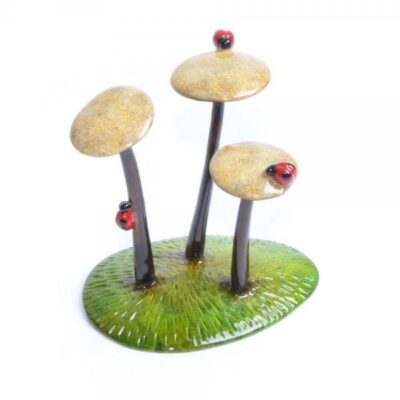 A group of three mushrooms sitting on top of grass.