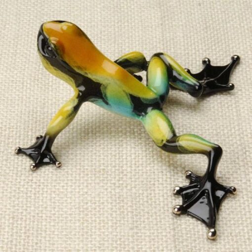 A small glass frog sitting on top of a table.