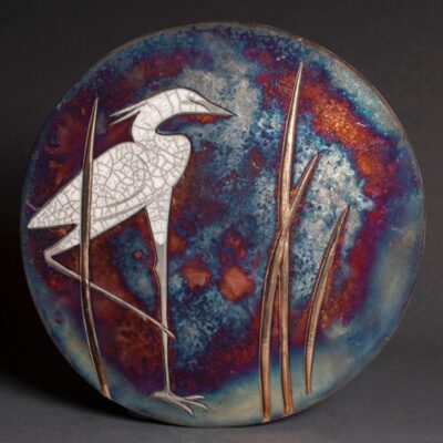 A ceramic plate with an image of a bird on it.
