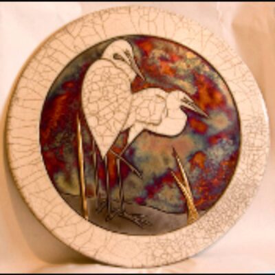 A decorative plate with an image of two birds.