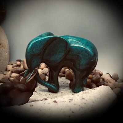 A small elephant statue sitting on top of rocks.