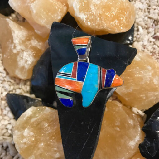A colorful pendant sitting on top of some rocks.