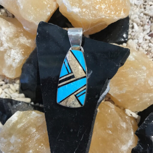 A close up of a necklace on some rocks