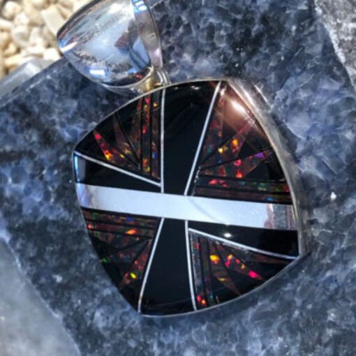 A black and white pendant sitting on top of a rock.