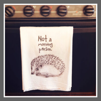 A tea towel with an image of a hedgehog.