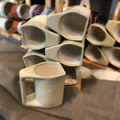 A stack of cups with the same design as the mugs.