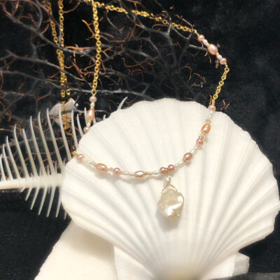 A shell with pearls and a glass bead necklace.