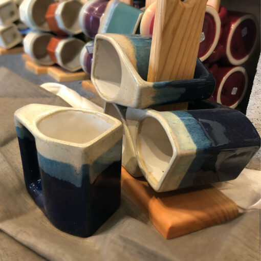 A close up of cups on display in front of wooden holders.