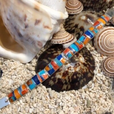 A close up of a bracelet on some shells