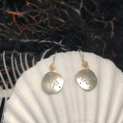 A pair of earrings sitting on top of a shell.