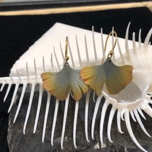 A pair of earrings sitting on top of a white object.