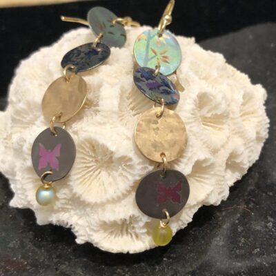 A white coral with some gold and colorful earrings