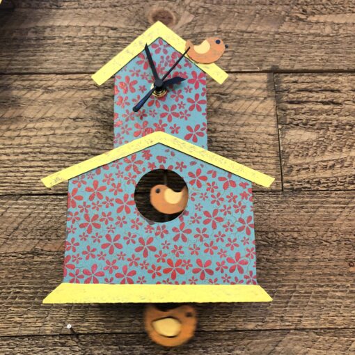 A bird house with two birds on it.