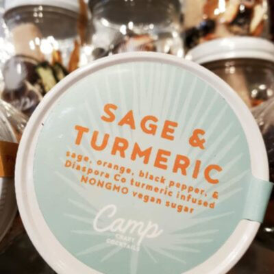 A container of sage and turmeric is sitting on the counter.