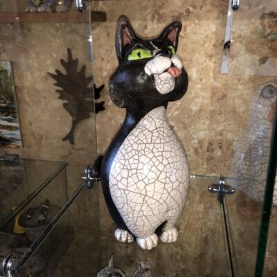 A cat statue sitting on top of a glass table.