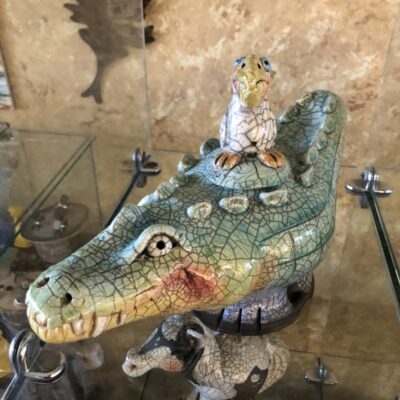 A statue of an alligator and a mouse on display.