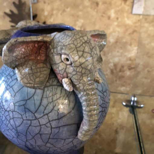 A close up of an elephant head on a vase