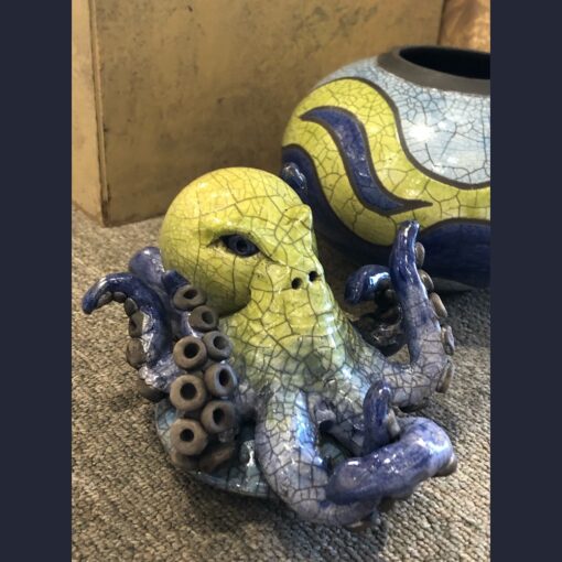 A yellow and blue octopus sitting on the floor.