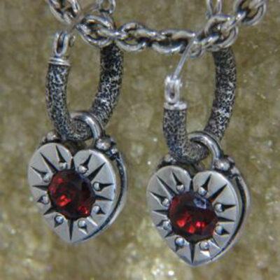 A pair of earrings with red stones on them.