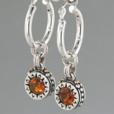 A pair of silver earrings with orange stones.