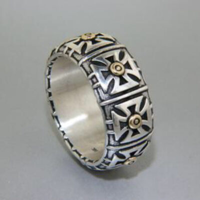 A silver ring with gold crosses on it.