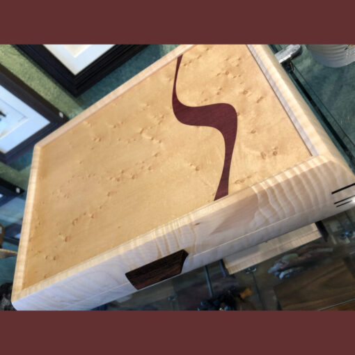 A wooden box with a brown design on it.