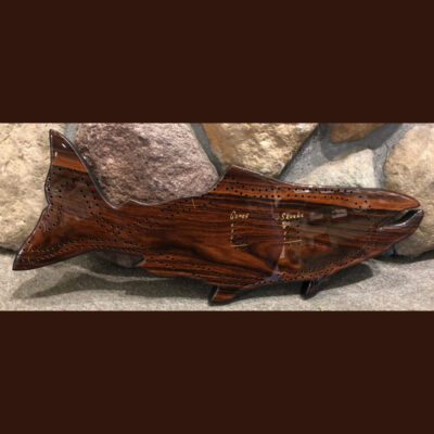 A wooden fish is sitting on the ground.