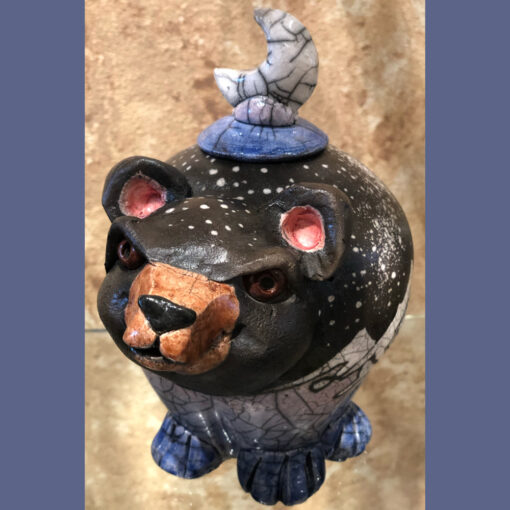 A bear figurine with a hat on top of it.